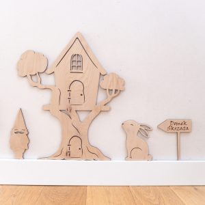 Drewniana dekoracja do pokoju dziecka w kształcie domku dla skrzata usytyowanego na drzewie.
